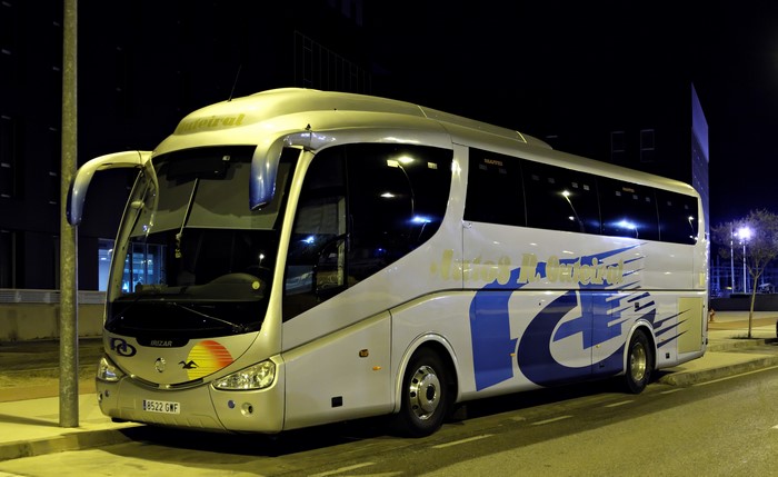 Silver Irizar bus with blue logo at night