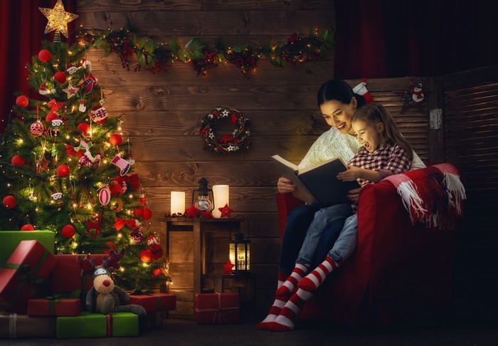 Mother and Daughter Reading by Christmas Tree