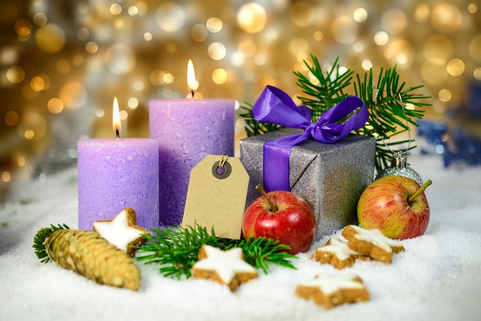 Christmas candles, gift, apples, and cookies in snow