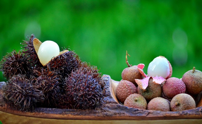 Rambutan and Lychee fruits in a wooden bowl