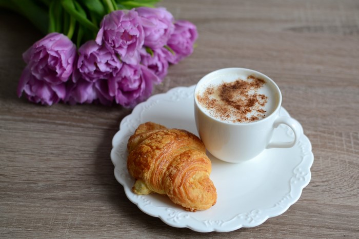 Cappuccino, Croissant, and Purple Tulips on a Wooden Table