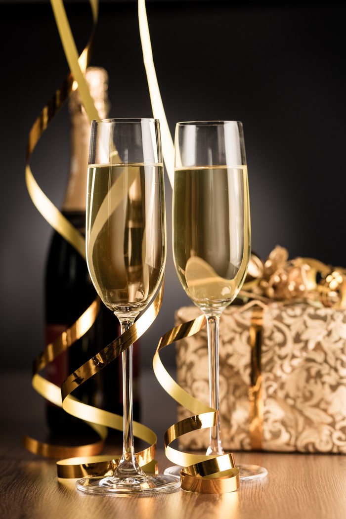 Champagne glasses and bottle with gift and ribbons