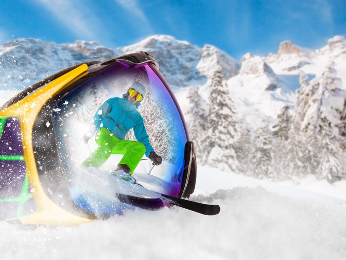 Skier reflected in ski goggles on snowy mountain