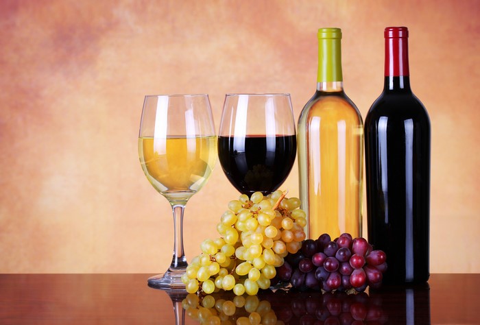 Two bottles of wine with glasses and grapes