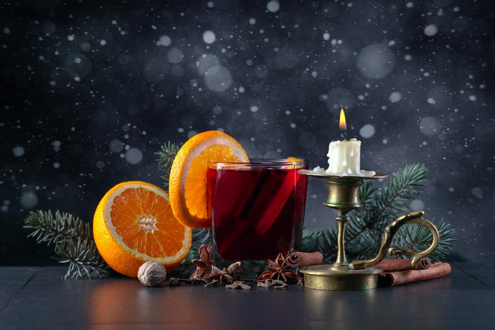 Mulled wine with oranges, cinnamon, and candle