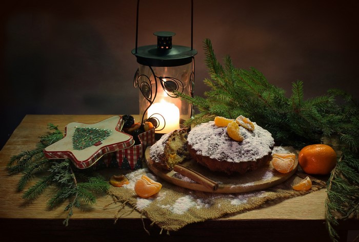 Christmas still life with cake, lantern, and pine branches