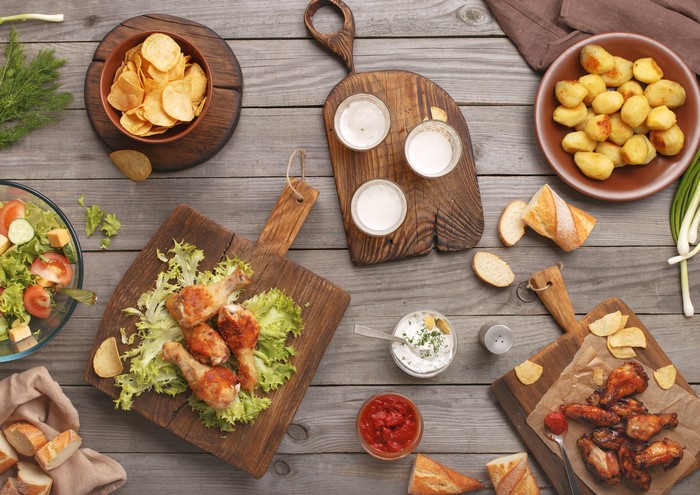 Roast Chicken, Chips, Salad, and Potatoes on Wood
