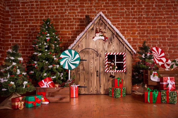 Christmas scene with trees, gifts, and a gingerbread house
