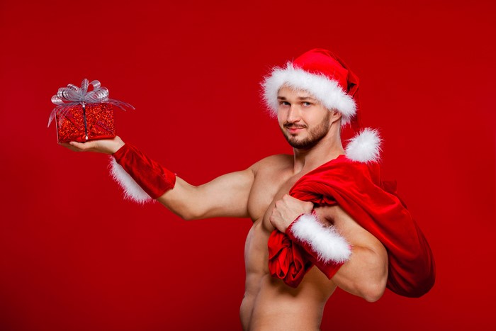 Man in Santa hat holding gift and sack