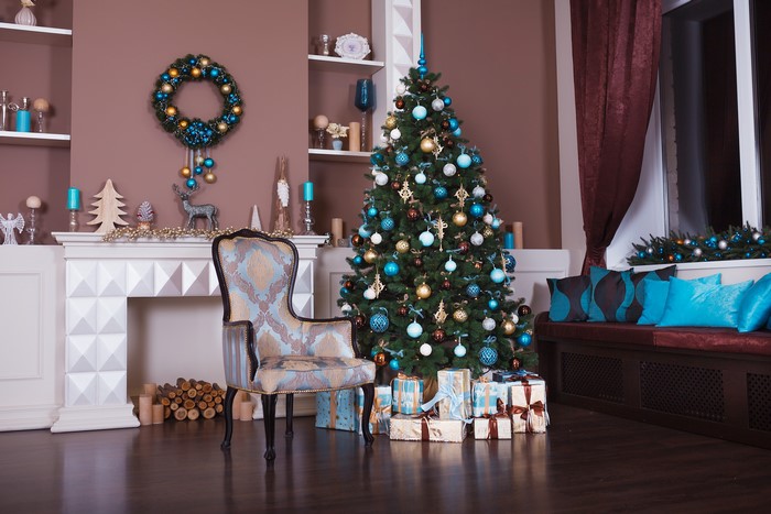 Christmas interior with tree, fireplace, and chair