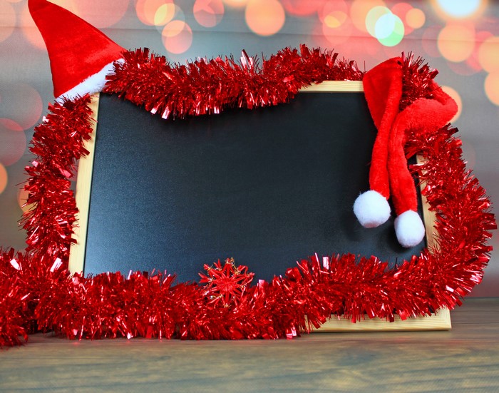 Christmas blackboard with Santa hats and tinsel