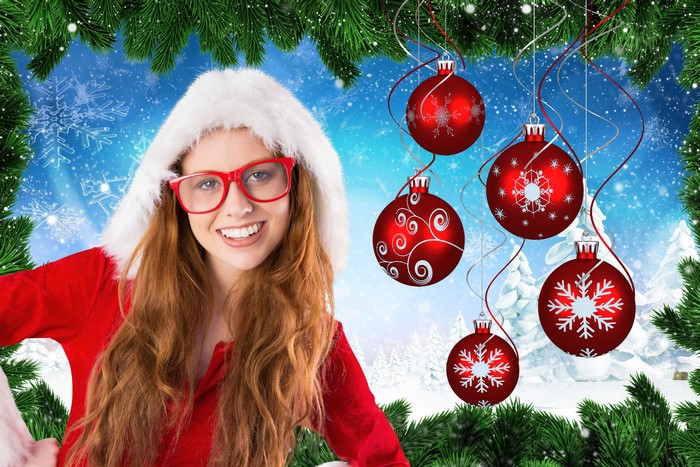 Redhead girl in Santa hat with glasses and Christmas ornaments