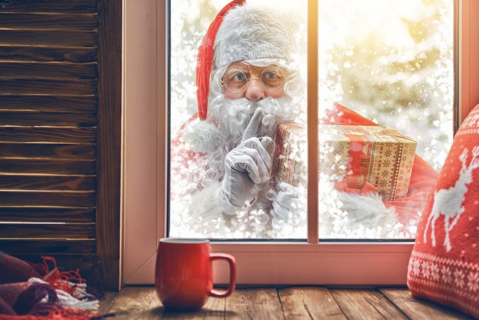 Santa Claus with a gift at the window