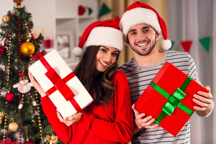 Couple in Santa hats with Christmas gifts