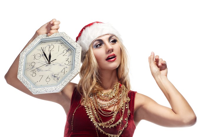 Woman in Santa hat holding a clock