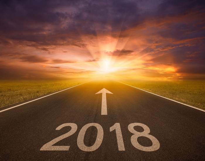 Road with 2018 and arrow towards sunrise