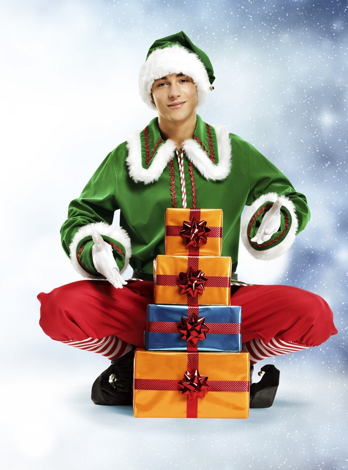 Young man dressed as a Christmas elf with gifts