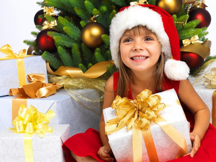 Girl in Santa hat with Christmas gifts