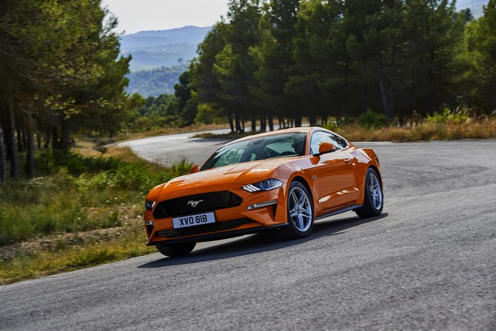 Orange 2018 Ford Mustang GT on a winding road