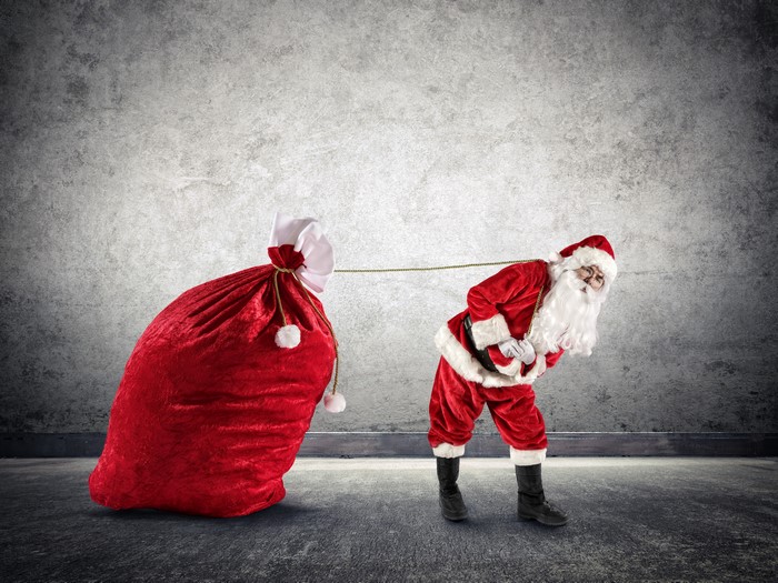 Santa Claus pulling a large red gift bag