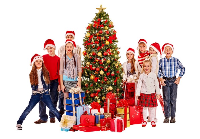 Children in Santa hats with Christmas tree and gifts