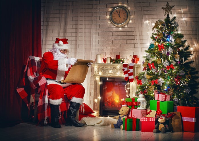 Santa Claus Sitting by Fireplace with Christmas Tree 4K