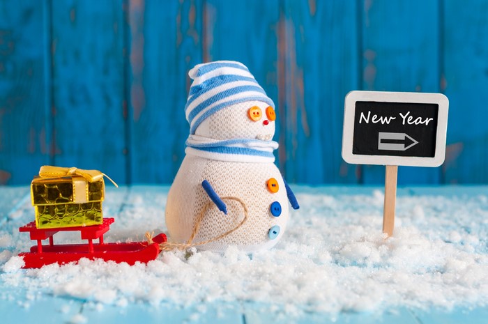 Snowman with gift on sled and New Year sign
