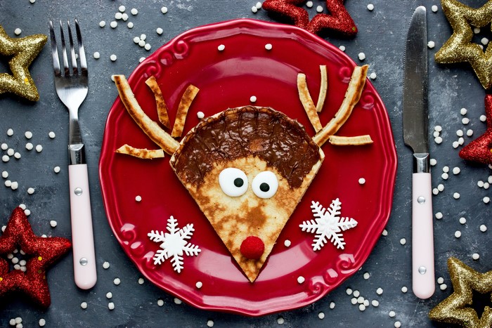 Christmas reindeer pancake with Nutella on a red plate
