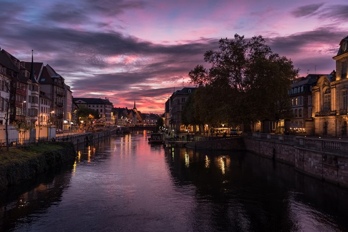 Strasbourg river at dusk with buildings and boats