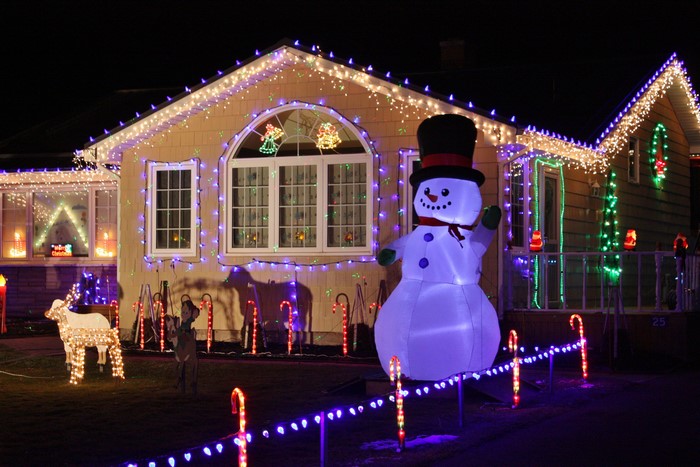 Christmas lights on a house with a snowman decoration