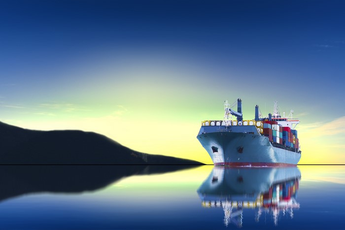 Container Ship at Sunrise with Mountain Reflection