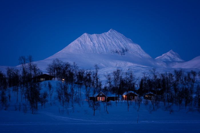 Snowy mountains and cabins at dusk