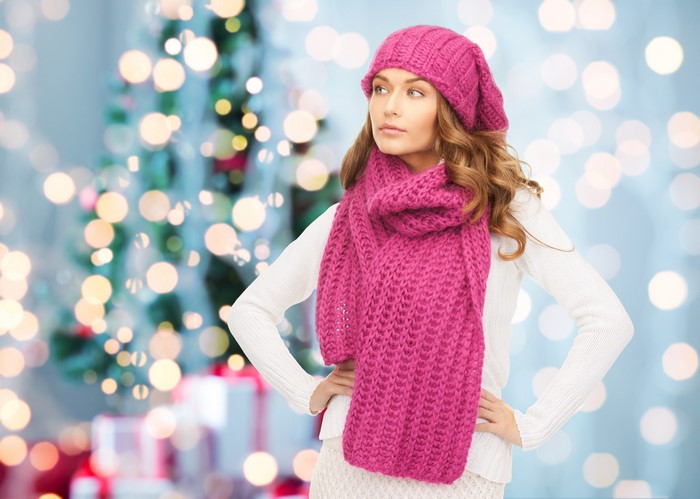 Woman in pink winter hat and scarf with Christmas tree