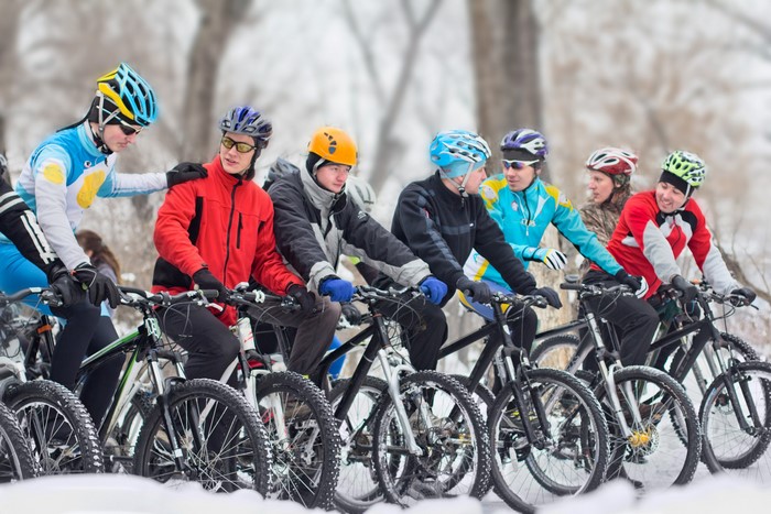 Group of cyclists in helmets in the snow