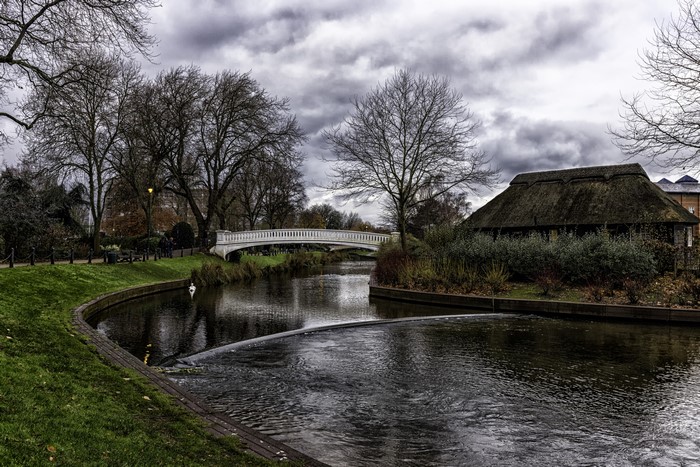 River with bridge and thatched house