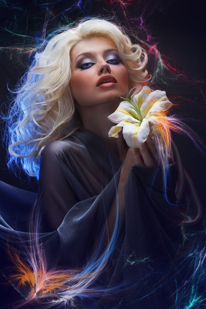 Blonde woman with lily and colorful light effects