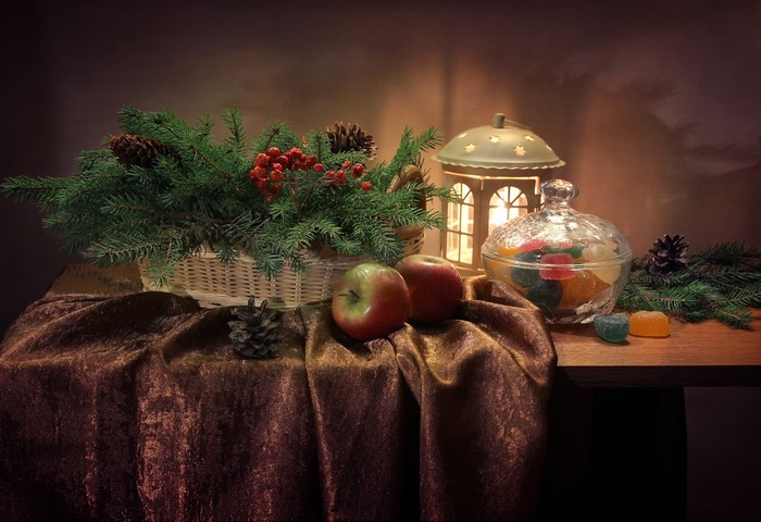 Christmas still-life with apples, pine cones, and a lantern