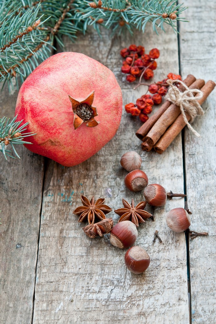 Pomegranate, Cinnamon, Nuts, Star Anise, and Rowan Berries on Wood