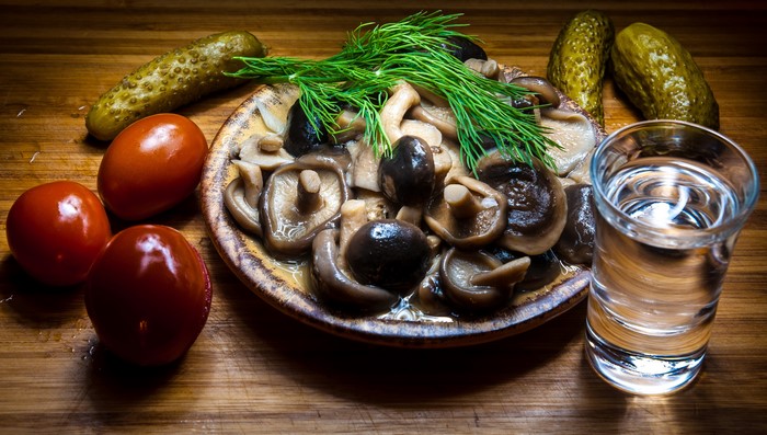 Pickled mushrooms with tomatoes, cucumbers, dill, and vodka