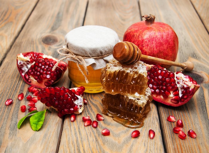 Honey, Pomegranates, and Honeycomb on Wood