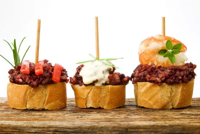 Three tapas on bread with toothpicks