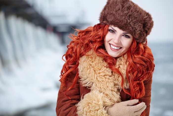 Redhead girl in winter hat and coat smiling