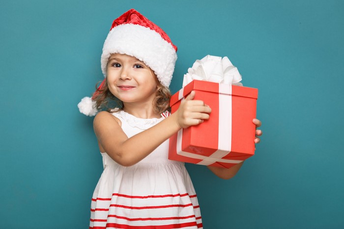 Girl in Santa hat holding a Christmas gift