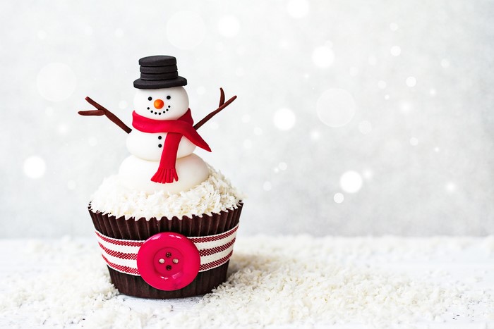 Cupcake decorated as a snowman with a red scarf and hat