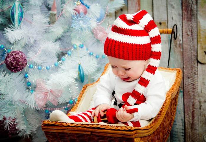 Baby in Christmas hat and stockings in a sleigh