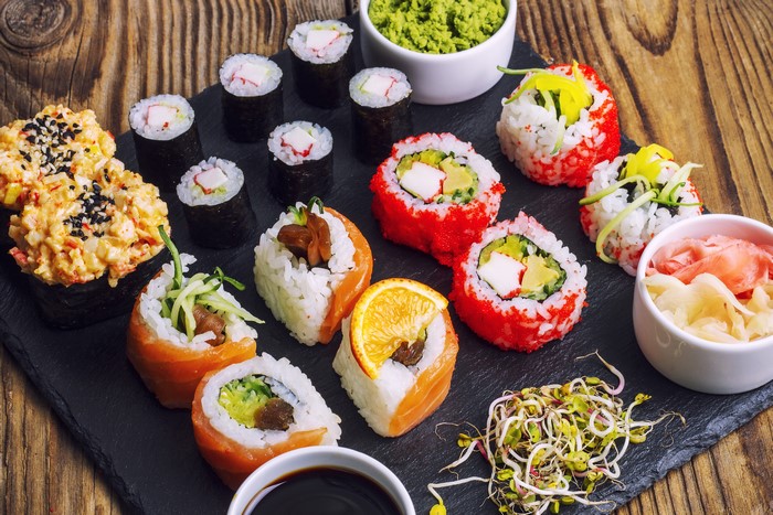 Sushi platter with various rolls and accompaniments
