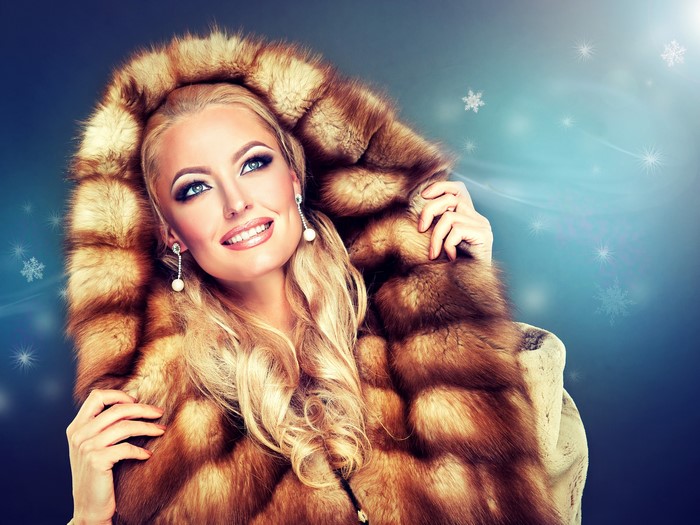 Blonde woman in fur coat with snowflakes