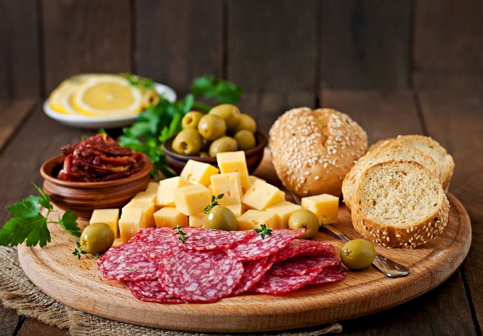 Sausage, Cheese, Olives, and Bread on a Cutting Board