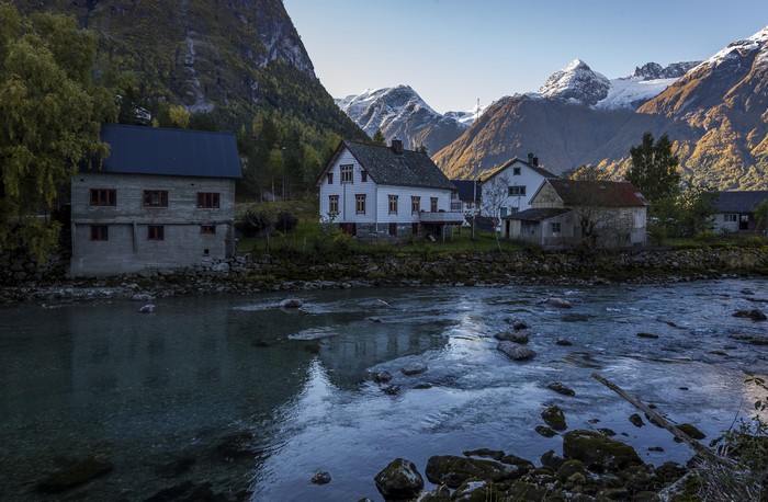 Houses by a river in a mountainous landscape