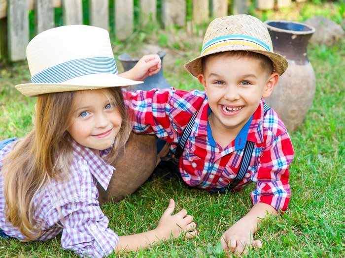 Two Children Wearing Hats in a Garden